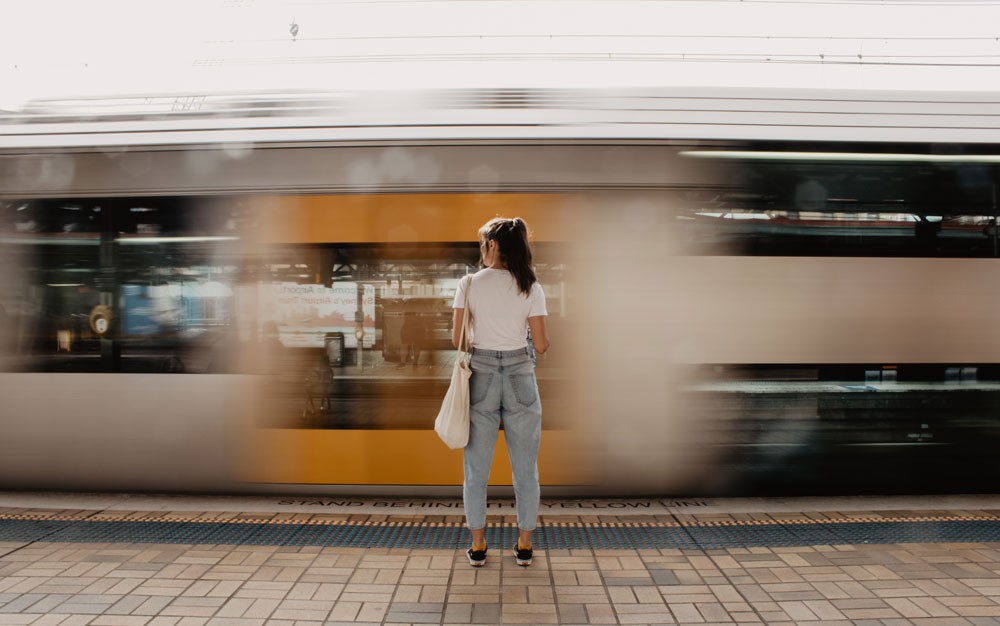 chica morena de espaldas y delante suyo el metro